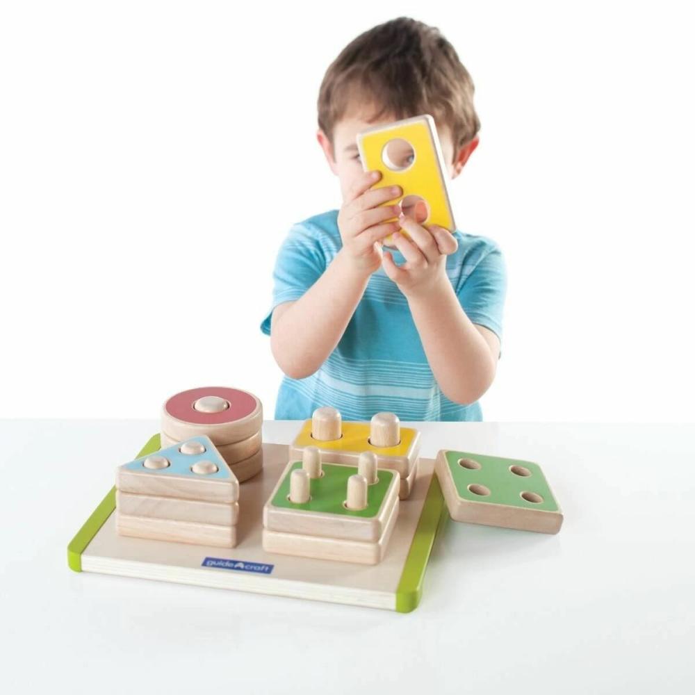 Kid playing with a stack and shape sorting toy and learning math and algebra