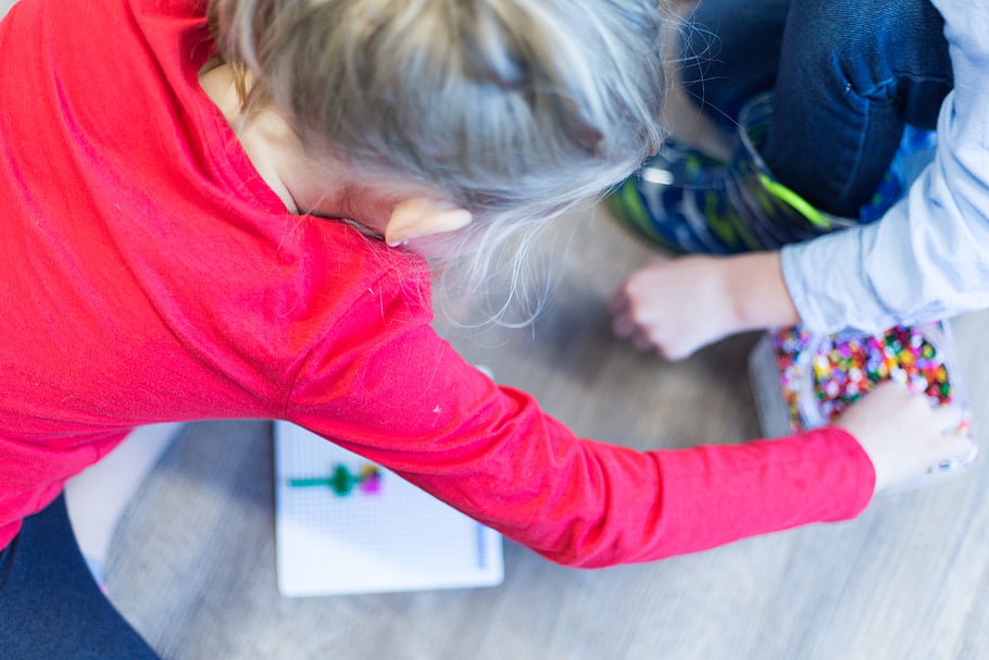 Kids playing with beads in Montessori play