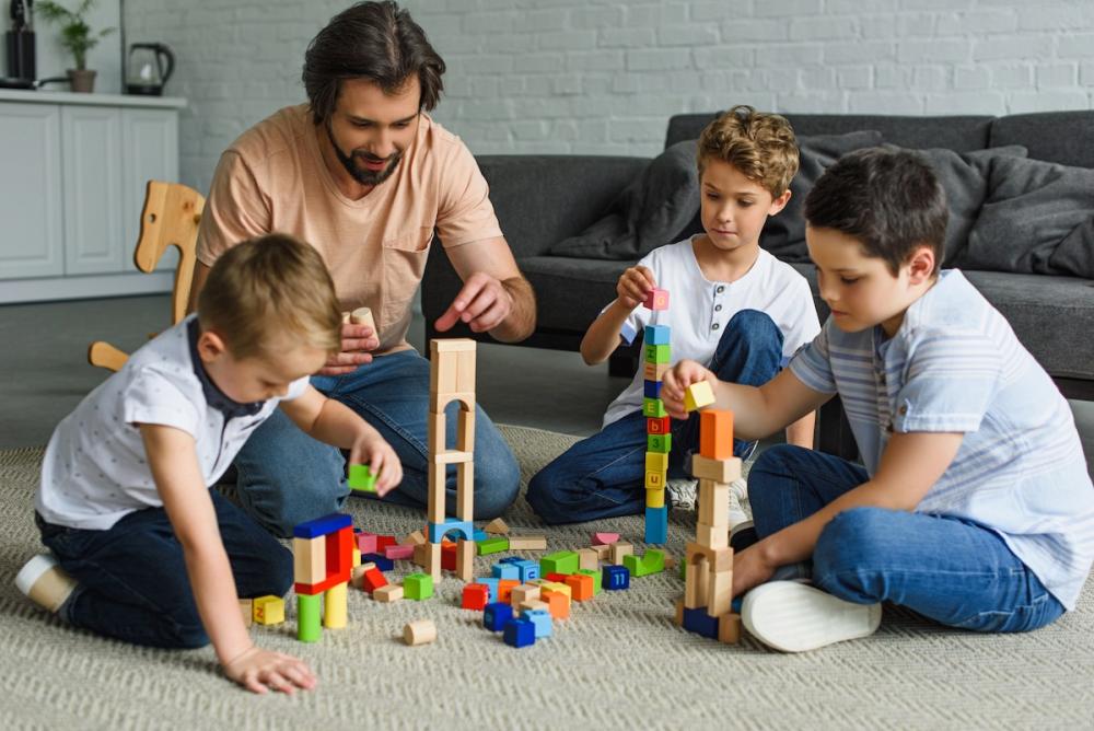 Kids and father playing with wooden building blocks