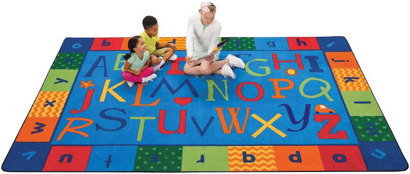 Kids and teacher sitting on a calming blue rug
