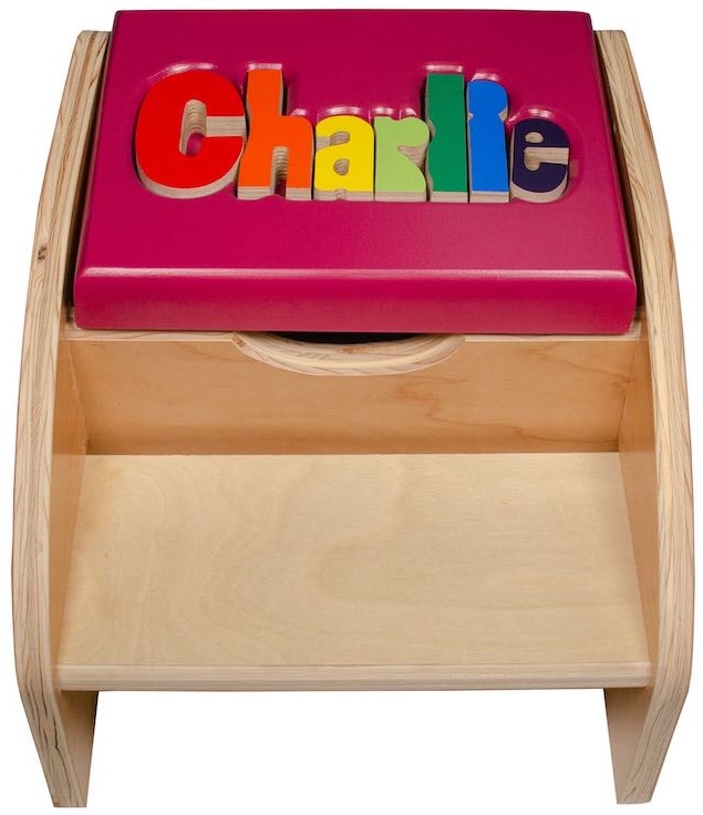 A Personalized Step Stool in natural color but with the seat painted in child-safe plum color with the name Charlie puzzled in alphabet blocks in the seat. Part of our kids furniture collection