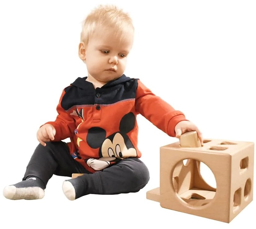Leo, a young toddler, is playing with the Montessori shape sorter cube